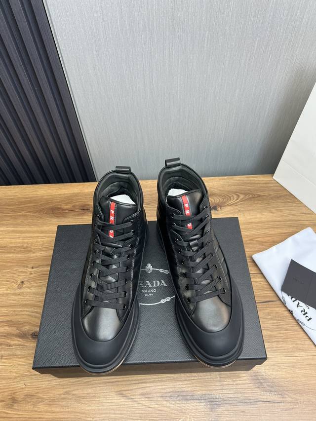 Factory price Prada leather, pure original leather cushion high top boots made of imported Napa cowhide with open edges and shiny leather, featuring classic red PRAD letter badges on the tongue, showcasing the brand's style. Geometric cutting