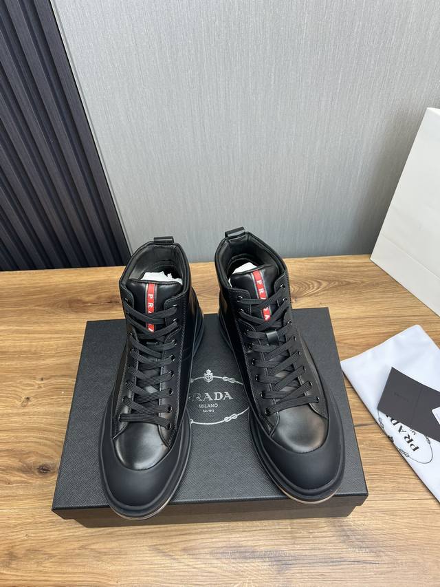 Factory price Prada leather, pure original leather cushion high top boots made of imported Napa cowhide with open edges and shiny leather, featuring classic red PRAD letter badges on the tongue, showcasing the brand's style. Geometric cutting